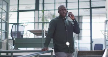 Erkek çalışan yürüyüş yolunda yürüyor ve akıllı telefon görüşmesine başlıyor. Proje sohbetinde dijital simgeleri manipüle ediyor. Teknoloji, iletişim, yenilik, işbirliği, modern, kurumsal, gelecekçi