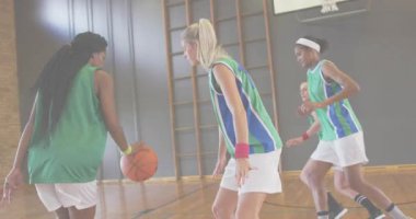 Turuncu girdabın izini sürerek basket oynayan bir kadın sayı yapmak için takım arkadaşına pas atıyor. Sporcular, takım çalışması, eylem, spor, rekabet, fitness, motivasyon