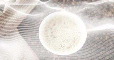 Başlangıçta şeffaf kumaşlar beyaz kahve fincanını ortaya çıkarmak için çizgili kumaş ve fasulyeler arasında sürükleniyordu. Minimalist, köylü, rahat, aromatik, durgun hayat, aşçılık, dokuma