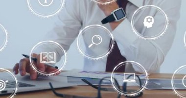 Bilgisayarda daktilo eden ve veri analizine yardım eden simgeler yüzerken basılı çizelgeleri inceleyen bir işadamı. Kurumsal, profesyonel, üretkenlik, dijital, analitik, çalışma alanı, modern