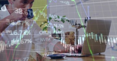 Dizüstü bilgisayarda yazarken kahve fincanı tutmak, ofis masasında stok dosyalarıyla oturmak. İş, girişimcilik, çalışma alanı, modern, üretkenlik, mali, dijital