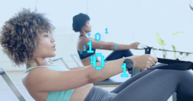 Kürek çeken iki kadın, fitness eğitmeni kılavuz formunu oluştururken ikili kod oluşturuyorlar. Kardiyo, eğitim, dijital, motivasyon, atletik, sağlık, hareket