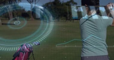 Golfçü sürücüyü geriye doğru savuruyor, golf rakamı ölçümleri sağlayan yüzüklerle vuruşu bitiriyor. Atletik, analitik, hassasiyet, açık hava, performans, teknoloji, sağlık