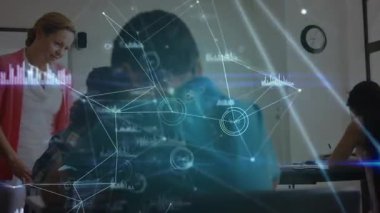 Öğretmen sınıfta yazan erkek öğrenciye yaklaşıyor ağ hatları titreşirken rehberlik sunuyor. Eğitim, teknoloji, akıl hocalığı, dijital, öğrenme, yenilik, işbirliği