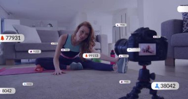 Spor salonu eğitmeni kamerayı selamlıyor, mor paspasın üzerinde geriniyor yüzen tezgahlar uzanarak tırmanıyor. Yoga, sağlık, çevrimiçi koçluk, spor, esneme, motivasyon, ev ortamı