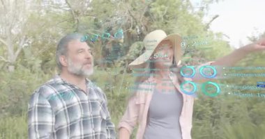 Üst düzey çift yürüyüş yolu ve görüntüye işaret ederek bitki örtüsü verilerini inceleyen AR çizelgeleri ortaya çıkıyor. Açık hava, arkadaşlık, dijital, yenilik, doğa, keşif, görselleştirme