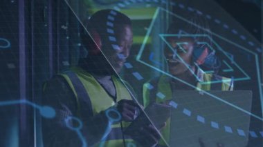 Bitki teknisyenleri tableti tıklatıyor ve bilgisayarı işaret ediyor. Çıktı istatistikleri için AR güncellemesi başlatılıyor. Sanayi, işbirliği, teknoloji, dijital, yenilik, imalat, takım çalışması