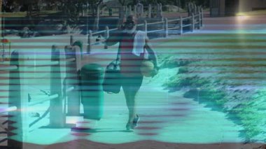 Adam liman yoluna telefonda konuşurken ve spor antrenmanı için basketbol çantası taşırken giriyor. Açık hava, boş zaman, fitness, şehir, eğlence, sağlıklı, aktif