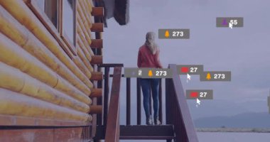 Kabin güvertesine çıkan bir kadın sosyal medya simgelerini patlatıyor aşırı yükleme yapıyor. Doğa, dinginlik, yansıma, farkındalık, dijital aşırı yüklenme, minimalizm, açık hava