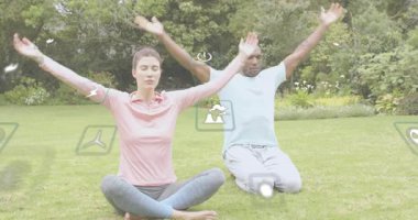 Kadın ve erkek gözlerini kapar ve sağlık başlatır. Yoga akışını yüzen ikonlarla çimlere odaklar. Sağlık, uyum, meditasyon, sükunet, çevre dostu, doğa, farkındalık.