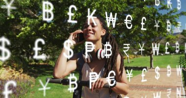 Parktaki tuğla yolda bir kadın, elinde akıllı telefon, üzerinde yüzen para sembolleri olan scooter tutuyor. Kentsel hareketlilik, açık hava eğlencesi, canlı, aktif yaşam tarzı, doğal çevre, modern teknoloji