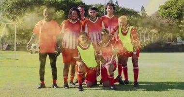 Futbol sahasında poz veren spor takımı sol taraftan gelen altın parçacıklar birliği gösteriyor. Atletizm, takım çalışması, rekabet, canlılık, açık hava, uyum, hareketsizlik