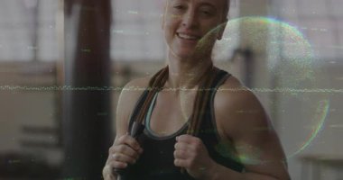 Spor salonunda ip tutan, başını eğen ve atladıktan sonra nefes alan bir kadın. Atletik, sağlıklı, motivasyon, egzersiz, modern, siluet, sağlık