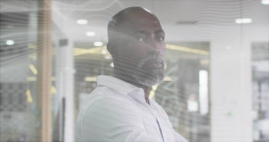 Beyaz gömlek giyen ve modern ofiste, dekoratif cam bölmenin arkasında duran adam. Profesyonel, kurumsal, modern, işyeri, liderlik, yürütme, ciddi