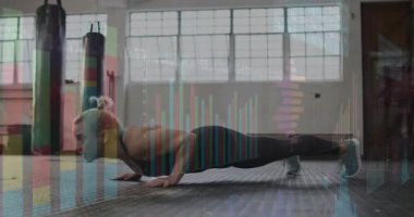 Kereste tutan fitness antrenörü ve kum torbalarıyla gövdesini paspasın üzerine koyuyor. Kuvvet, vücut ağırlığı, egzersiz, sağlık, atletik, spor salonu, kararlılık
