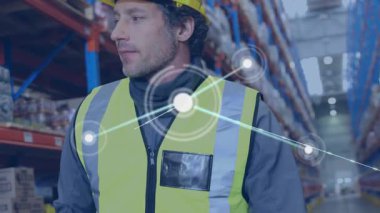 Ağ bağlantısı kurarken depo çalışanı koridor taraması yaparak envanteri takip ediyor. Lojistik, otomasyon, tedarik zinciri, teknoloji, takım çalışması, sanayi, bağlantı