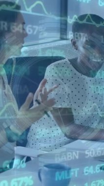 Grafiklerin ve ticaret kurulunun animasyonu, çok ırklı meslektaşlar ofiste dizüstü bilgisayarla fikirlerini paylaşıyorlar. Dijital bileşik, çoklu pozlama, takım çalışması, finans, borsa, yatırım ve teknoloji.