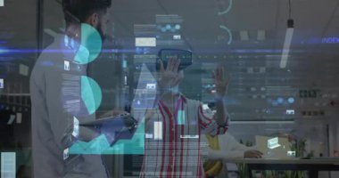 VR kullanıcısı kulaklık takıyor ve teknoloji merkezinde dizüstü bilgisayar tutan sakallı bir adamın yaptığı bar çizelgelerini değiştiriyor. Gelecekçi, yenilikçi, takım çalışması, işbirliği, dijital, müteşebbis, veri görselleştirme