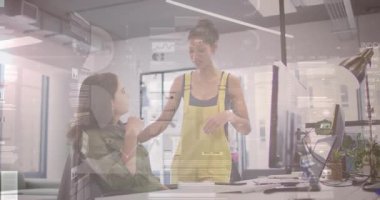 Önlüklü kadın ekrandaki iş arkadaşına işaret ediyor. Ofiste başını sallıyor. İşbirliği, takım çalışması, modern, profesyonel, iletişim, beyin fırtınası, üretkenlik