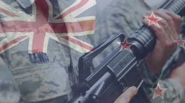 Kamera, üç askerin tüfekleri kavradığını, bayrak kaplamasının savunma taliminde kaybolduğunu gösteriyor. Askeri, disiplin, cesaret, kamuflaj, takım çalışması, açık hava, vatanseverlik.