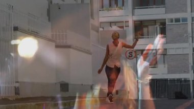 Müzisyen, tef çalkalayarak bir kadına dönüşüyor. Tabelanın önünden geçiyor. Müziği şehir ritmine çeviriyor. Performans, kentsel, canlı, ritim, yaşam tarzı, sokak, enerji