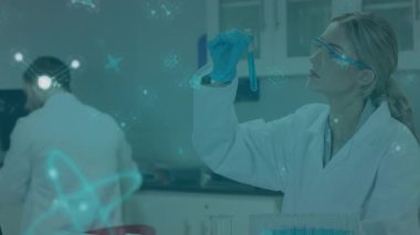 Laboratuvara giren araştırmacı, moleküller olarak analiz için mavi örnek tüpünü inceliyor. Bilim adamı, laboratuvar, kimya, yenilik, işbirliği, hassasiyet, bilimsel