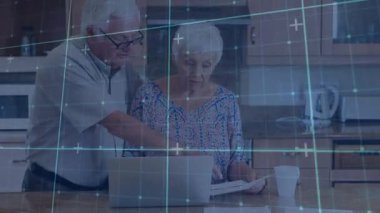 Mutfağa varan yaşlı çift dizüstü bilgisayardaki mali belgeleri inceliyor ve bütçeyi güncelliyor. Aile, işbirliği, teknoloji, yerli, yaşam tarzı, rahatlama, nostalji