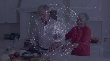 Kıdemli adam mutfakta soğan doğruyor ve yemek için yol gösteren kadınla sebze soteleniyor. Tezgah, aşçılık, birliktelik, arkadaşlık, rahat, modern, yaşam tarzı.