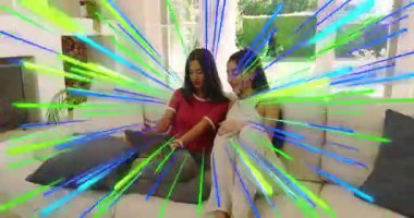 Dostlar tableti tıklatıyor, kanepede ekranı kaydırıyor, yeşil-mavi teknoloji serileri üretiyor. İşbirliği, teknoloji, bağlantı, yaşam tarzı, modern, canlı, iletişim