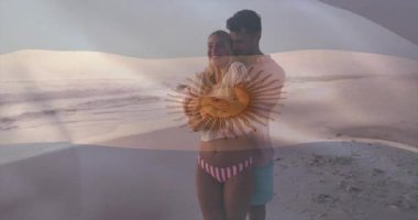 Sahilde yürüyen adamın kollarını kadının beline dolaması seyahat pazarlaması için yüzen kalp simgeleri. Romantizm, samimiyet, deniz kenarı, günbatımı, şefkat, rahatlama, çift