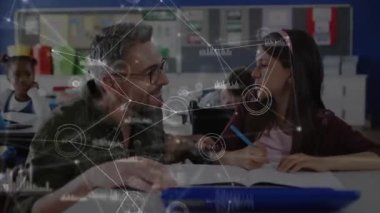 Eğitmen öğrencinin üzerine eğilirken aynı zamanda ders kitabına ve yazıya nabız ile rehberlik ediyor. Eğitim, akıl hocalığı, dijital öğrenme, sınıf, bilgi, odak, rehberlik