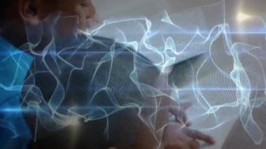 Not defterine notlar yazarken dijital dalgaların girdap oluşturmasına neden olan metni takip eden öğrenci. Eğitim, gençlik, yenilik, teknoloji, konsantrasyon, öğrenme, odaklanma