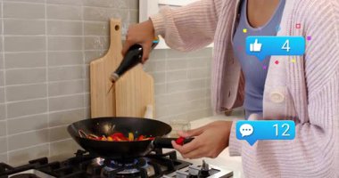 Ev yemekleri tavanın üzerine yağ serpiyor ve sosyal ikonlar nişan için tırmanırken sebzeleri karıştırıyor. Aşçılık, aşçılık, mutfak, yayın, sosyal medya, dijital, modern