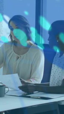 Dizüstü bilgisayarda raporları tartışan çeşitli kadın çalışanlar üzerinde grafik, harita ve numaraların animasyonu. Dijital bileşik, çoklu pozlama, iş, küresel, planlama, takım çalışması ve teknoloji kavramı.