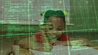 Öğrenci sınıfa kalem yazma kodu yerleştirirken yeşil ızgara öğrenme sürecini gösteriyor. Eğitim, teknoloji, yenilik, gençlik, konsantrasyon, kök, dijital