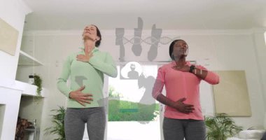 Yoga minderlerinde nefes alma pratiği yapan kadınlar sağlık veri ağını haritalamak için biyometrik örtüyü etkinleştiriyorlar. Sağlık, farkındalık, biyometik, bağlantı, sağlık teknolojisi, dinginlik, modern