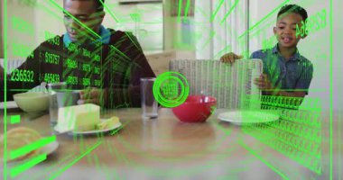 Çocuk tostu yağlayan adama doğru sandalyeyi çekerken, yeşil teknoloji takip edici konuşmaları örtüyor. Aile, etkileşim, yenilik, yerli, iletişim, bağlantı, teknoloji