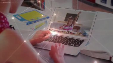 Gençler dizüstü bilgisayarda eğitim seansı başlatıyorlar. Çocuğun titreşim düğümlerinin arasında el kaldırmasına rehberlik ediyorlar. Uzaktan eğitim, dijital eğitim, çevrimiçi sınıf, gençlik gelişimi, eğitim teknolojisi