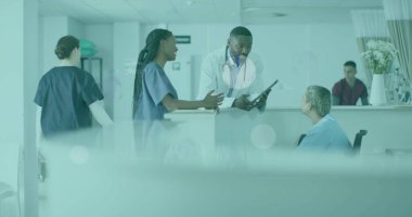 Hastane resepsiyonunda tekerlekli sandalyeyle hasta etrafında toplanan danışmanlar. Tıbbi, takım çalışması, profesyonel, sağlık hizmetleri, danışma, hastane, işbirliği