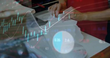 Kafe çalışanı katlıyor, bantlıyor, çörekleri kağıda döküyor ve borsa grafikleri işlerken paketliyor. Hamur işi, ambalaj, işçilik, verimlilik, serbest çalışma, modern, sanayi