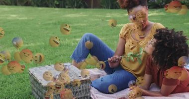 Arkadaşların çiçek açması ve yüzen emojiler tarafından pazarlama için çilek tatması. Arkadaşlık, açık hava, eğlence, kutlama, neşeli, rahat, hayat dolu.