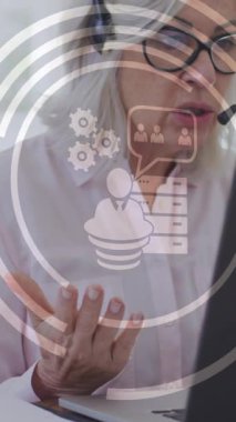 Ofiste kulaklık kullanan beyaz iş kadınının medya simgelerinin canlandırılması. küresel iş, finans, bağlantılar ve dijital arayüz konsepti dijital olarak oluşturulmuş video.