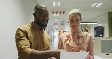 Ofis salonunda elinde yazılı kağıtlar olan sıradan giyinmiş meslektaşları inceliyorum. Şirket, takım çalışması, modern, profesyonel, iletişim, işbirliği, navigasyon