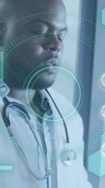 Afro-Amerikan erkek doktor üzerinde tıbbi veri işleme animasyonu. Küresel sağlık, bilim, tıp, araştırma, bilgisayar ve veri işleme kavramı dijital olarak oluşturulmuş video.