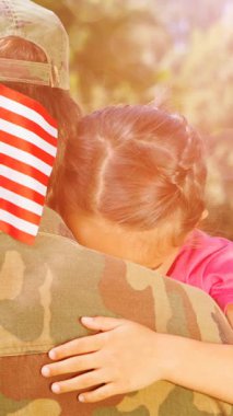 Erkek askerin ağaçların üzerinde Amerikan bayrağıyla kızını kucaklamasının animasyonu. Asker, dijital olarak üretilen aile imajına geri dönüyor..