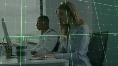 İki meslektaş laptoplarda yazı yazmaya başladı ve veri analizini taklit ederek yeşil şebekeyi etkinleştirdi. Teknoloji, üretkenlik, takım çalışması, yenilik, dijital, kurumsal, modern