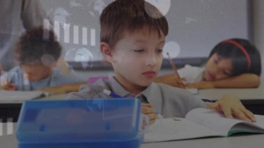 Sınıf öğretmeni masaların önünden geçiyor, kamerayı çalıştırıyor, öğrenciler gözetim altında kitap yazıyor. Eğitim, öğrenme, çocukluk, odaklanma, konsantrasyon, akademi, sınıf