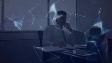 Bilgisayara bakarken akıllı telefondan konuşan orta yaşlı bir adam mavi düğümlerden teknoloji küresi üretiyor. Teknoloji, yenilik, bağlantı, veri görselleştirme, dijital çalışma alanı, geleceksel