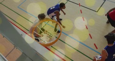 Spor mavisi oyuncu top girdikten sonra potaya doğru koşuyor ve sayı yapmak için gardiyanların üzerinden smaç basıyor. Dinamik, atletik, rekabetçi, enerjik, enerjik, hareketli, aksiyon, takım