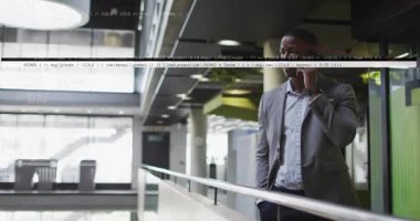 Akıllı telefondan kulağa yükselen bir adam, asma katta iş görüşmesine başlayan, dinlerken gülümseyen bir adam. Profesyonel, kurumsal, kentsel, modern, iş, iletişim, işyeri